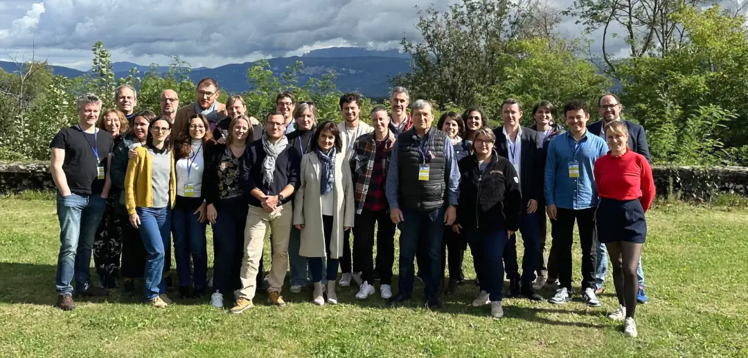Une photo de groupe des membres du conseils d'administration et des délégués à l'extérieur sous sous un ciel couvert