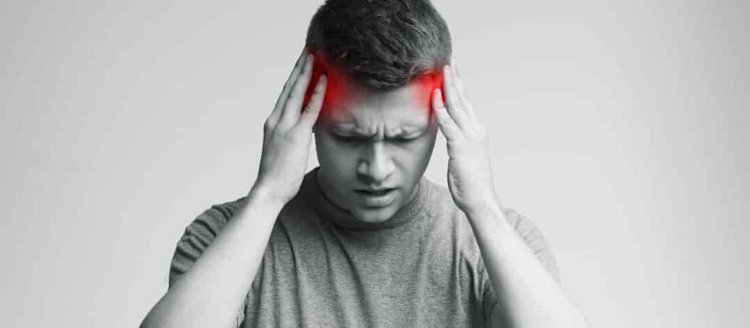 Jeune homme se tenant la tête des deux mains